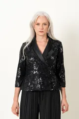 Chaqueta negra de encaje bordado, modelo cruzado con solapa de satén y mangas tres cuartos.