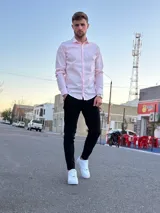 Camisa de manga larga color rosado, con cuello camisero y cierre frontal de botones.