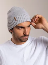 Gorro de lana azul con etiqueta de cuero sintético con logo de la marca en el frente.