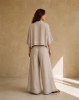 Pantalón ancho color beige de lino, con diseño de perneras holgadas y detalle de doble ruedo.