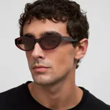 Gafas de sol con montura de acetato color borgoña (maroon) de forma ovalada/cat eye suave. Las lentes son polarizadas de color marrón.