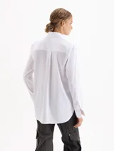 Camisa de algodón con lycra en color celeste claro, de corte clásico y manga larga. Presenta apliques de piedras de cristal en las puntas del cuello y una cartera oculta con botones.