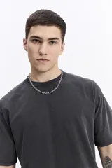 Remera lisa color gris oscuro con efecto acid wash, de corte oversize y escote redondo.