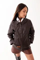 Campera de cuero color marrón oscuro, con cierre frontal, cuello clásico y diseño de corte recto.