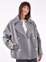 Tapado corto color beige claro, con cuello solapa, doble botonadura y corte holgado.