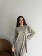 Conjunto de dos piezas color gris melange, confeccionado en tela de lanilla, compuesto por un buzo de manga larga con diseño cruzado al frente y un pantalón largo de corte holgado y tiro alto.
