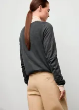Jersey de punto fino color gris oscuro, con cuello redondo y diseño recto de manga larga.