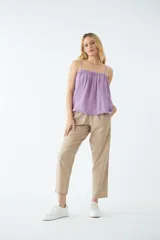 Blusa de tirantes finos ajustables, color lila, con diseño holgado y ruedo con terminación desflecada.