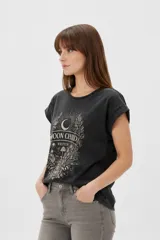 Remera azul marino de manga corta holgada con cuello redondo y estampa frontal de paisaje marino con fases lunares y flores.