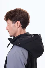 Campera técnica con capucha desmontable, diseño bicolor en negro y gris. Cuenta con cierre frontal termosellado, bolsillos laterales y bolsillo en el pecho con cierre, ideal para protección contra el viento y el frío.