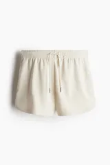 Short color crema de felpa liviana de mezcla de algodón, con cintura elástica revestida, cordón para ajustar y bolsillos laterales.