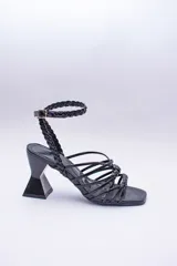 Sandalias de tacón geométrico con diseño de tiras finas lisas y trenzadas que se entrelazan en el empeine y tobillo. Cuentan con cierre de pulsera ajustable y punta cuadrada.