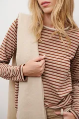 Remera de manga larga con diseño de rayas horizontales en azul y blanco, destacada por un cuello redondo en color bordó con costuras a la vista.