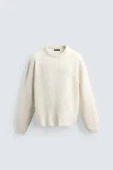 Jersey de punto con textura efecto pelo, corte boxy fit, cuello redondo y manga larga con acabados en rib.