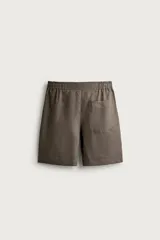 Bermuda de lino negro de corte relaxed fit, con cintura elástica ajustable mediante cordón y bolsillos frontales.