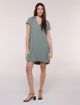 Vestido corto de lino color celeste con cuello camisero, escote en V, mangas cortas, bolsillos laterales invisibles y silueta holgada.