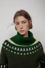 Jersey de punto con cuello subido y manga larga, diseño de jacquard con motivos geométricos en tonos verdes y crema.
