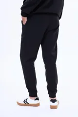 Pantalón de jogging de felpa, color beige, con cintura elástica ajustable mediante cordón y puños acanalados en los tobillos.