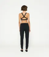 Top deportivo blanco de algodón orgánico con tirantes cruzados en la espalda y logo de minirayas.