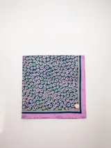 Pañuelo cuadrado de seda con estampado de flores en tonos violeta, verde y azul.