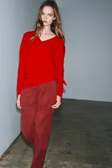Jersey de manga larga confeccionado en hilatura de lana 100%, con escote en pico y acabado de punto fino.