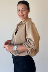 Camisa de algodón de corte oversize y calce relajado, con cuello camisero clásico, mangas largas con puños y ruedo irregular más largo en la parte posterior.