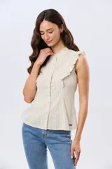 Musculosa de lino rayada con cuello mao y volados en los hombros. Presenta diseño de rayas verticales y aplique de etiqueta con logo en la parte posterior.