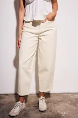 Jean de mujer color crema o blanco roto, de corte baggy y tiro medio. Confeccionado en algodón con un pequeño porcentaje de elastano.