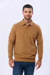 Buzo de felpa color verde oscuro, con cuello tipo polo, cierre frontal parcial con botones y bolsillos laterales. Presenta puños y ruedo acanalados.