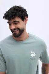 Remera verde militar de corte regular, con estampa abstracta y floral en la espalda y texto descriptivo de la marca Brooksfield.
