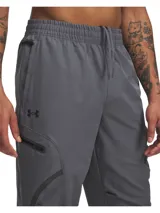 Pantalón cargo deportivo Under Armour modelo Unstoppable, color gris, con tecnología UA Storm repelente al agua, tejido elástico en cuatro direcciones, cintura elástica con cordón interno y múltiples bolsillos con cierre.