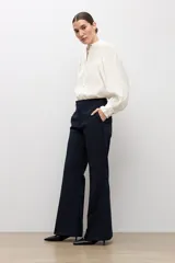 Pantalón sastrero de corte flare, color azul marino, con bolsillos laterales y trabillas para cinturón.