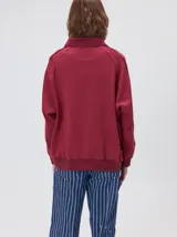 Buzo de algodón con cuello alto y cierre frontal parcial. Presenta bolsillos laterales con cierre y cuello con interior en contraste. Diseño de corte oversize.