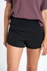 Short negro de tiro medio con corte ligeramente acampanado, confeccionado en tejido técnico de secado rápido con cintura elástica ancha.