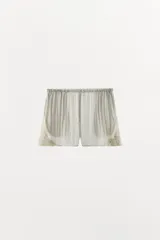 Shorts de tiro medio y cintura elástica, confeccionados en hilatura con mezcla de viscosa. Presentan diseño fluido y detalles de encaje bordado a contraste en los laterales.