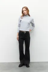 Polera de tejido de punto con cuello alto y diseño de rayas verticales sutiles. Presenta un ajuste al cuerpo y mangas largas.