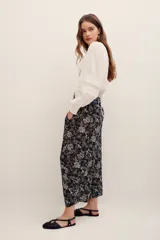 Pantalón tipo babucha de algodón, con estampado floral en tonos oscuros y diseño holgado.