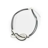 Gargantilla de cuero negro con doble tira y dije plateado en forma de nudo.