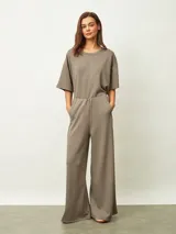 Enterito de una sola pieza color azul oscuro, con cuello redondo, mangas cortas y pantalón de corte ancho. Presenta cintura elástica y diseño minimalista.
