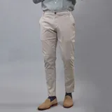 Pantalón de gabardina color beige claro, de corte ajustado y tiro medio, con cierre de botón y bolsillos laterales y traseros.