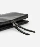 Cartera transversal mediana de poliuretano color negro, con cierre por imán, separadores con cremallera y asa de cadena.