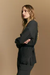 Polera de tejido de punto color marrón, con cuello alto y diseño de líneas verticales en el frente que aportan estructura. Presenta un calce relajado y mangas largas con puños ajustados.