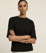 Blusa básica de algodón con corte oversized, cuello redondo y mangas cortas con sisas desplazadas. Diseño liso sin estampados.