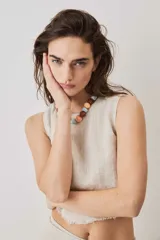 Blusa cropped color chocolate, de silueta suelta y cuello redondo, con terminación de bordes deshilachados.