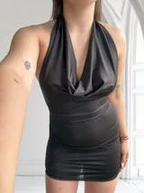 Minivestido negro de satén con escote halter y espalda descubierta.