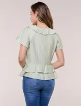 Blusa de satén texturizado color verde menta, con escote en V y volados que bordean el cuello. Presenta mangas cortas acampanadas y doble nivel de volados en la parte inferior, formando una silueta péplum.