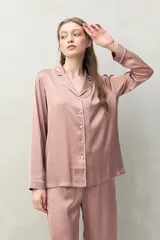 Camisa de pijama color verde menta, de silueta clásica y tacto sedoso. Confeccionada en tejido satinado con leve elasticidad, presenta cuello camisero, cierre frontal con botones y detalles de vivo blanco que realzan el diseño.