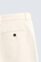 Pantalón de corte recto confeccionado en tejido compacto de algodón con estructura twill. Presenta cierre frontal con cremallera y botón, bolsillos laterales y bolsillos traseros de vivo con botón.