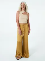 Pantalón negro de tela satinada, corte palazzo, cintura alta con elástico y lazo ajustable.
