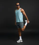 Bermuda deportiva masculina gris con cintura elástica, bolsillos laterales y cordón de ajuste.